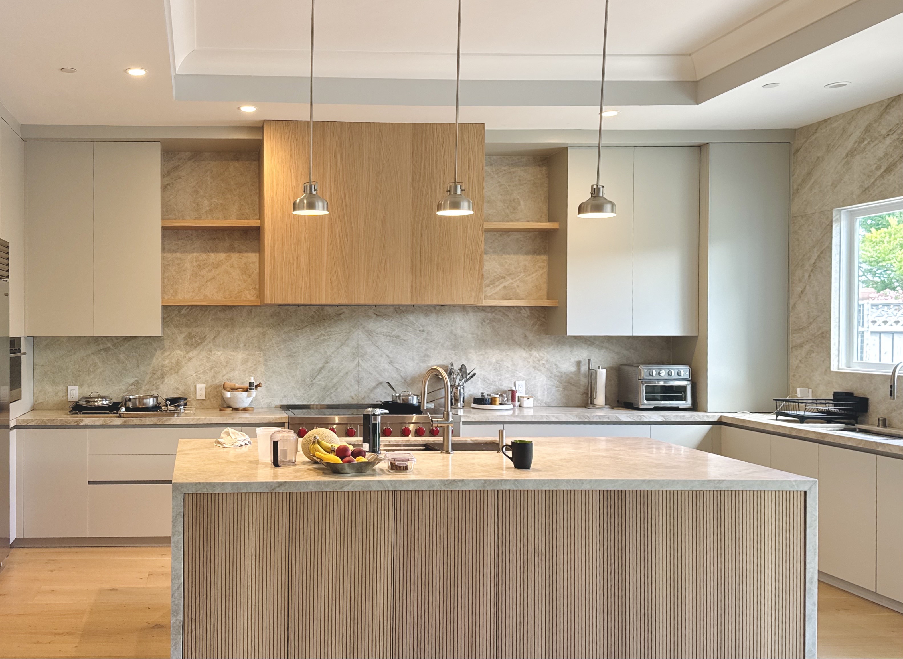 Custom kitchen with wood cabinetry and marble backsplash
