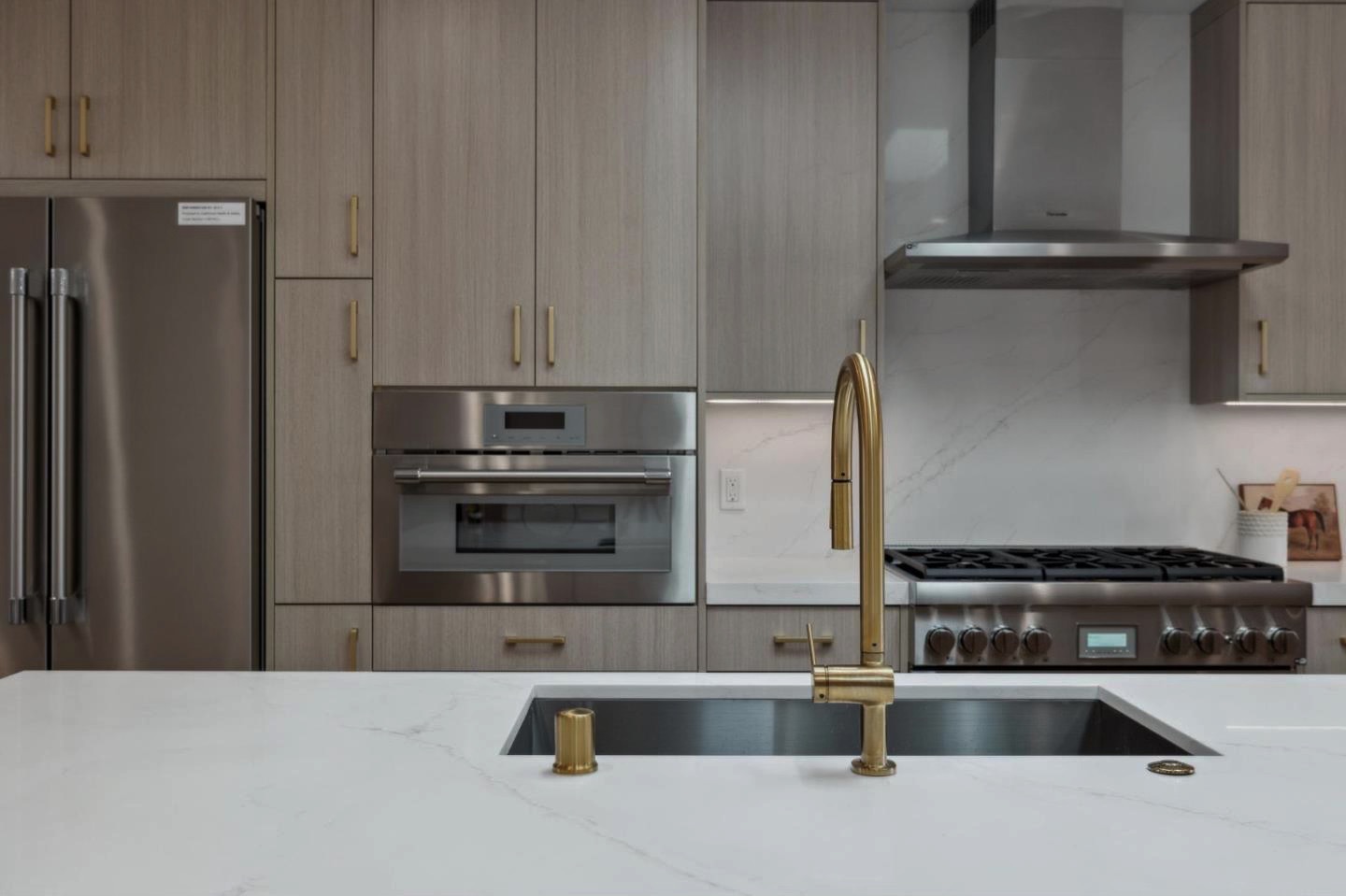 Kitchen detail with marble counters and gold faucet